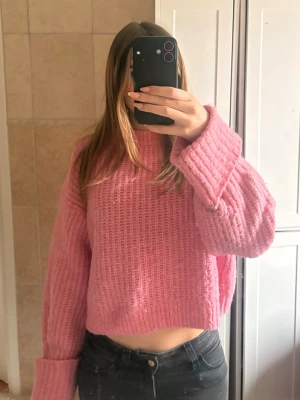 Rosa oversized stickad tröja - Mysig rosa stickad tröja med oversized passform och breda ärmar. Tröjan har en kortare modell, ribbstickade muddar vid ärmslut och nederkant. Perfekt för dig som gillar en avslappnad och trendig stil.💕💕