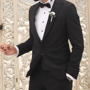 Svart klassisk smoking  - Säljer en stilren kostym i mycket gott skick, bestående av kavaj med matchande skjorta inuti samt byxor. Kostymen har endast använts en gång och är därför i nyskick. Perfekt för fest, bröllop, jobb eller andra tillfällen där du vill klä dig extra snyggt. Passar dig som har storlek M. Ett utmärkt tillfälle att få en elegant och komplett kostym som knappt är använd.