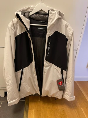 Vit sail racing jacka/windbreaker - Jackan är helt ny och aldrig använd. Säljer då den aldrig kommit till användning. Passar perfekt för segling, skidåkning, är även vindtät och vattentät. Justerbara funktioner för en perfekt passform. Prislappen hänger dessutom kvar!