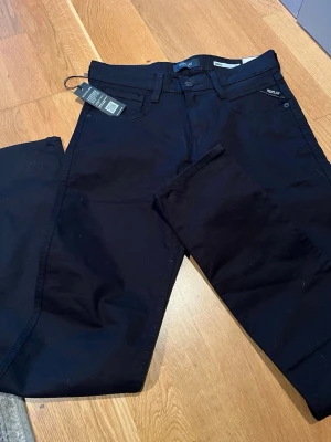 Svarta jeans från Replay - Snygga svarta jeans från Replay med power stretch för extra komfort. Klassisk femficksmodell med smal passform och bälteshällor. Jeansen har diskreta detaljer och är tillverkade i ett mjukt, stretchigt material som sitter riktigt bra. Är enkla att matcha och passar bra till väldigt många outfits 