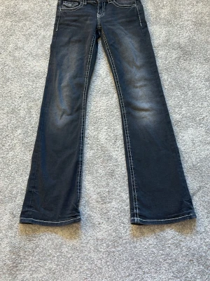 Mörkblå bootcut jeans Gina Tricot - Snygga mörkblå bootcut jeans från Gina Tricot med kontrastsömmar och lätt slitning på framsidan. Klassisk femficksmodell i mjukt denimtyg, perfekta för en trendig och avslappnad look.