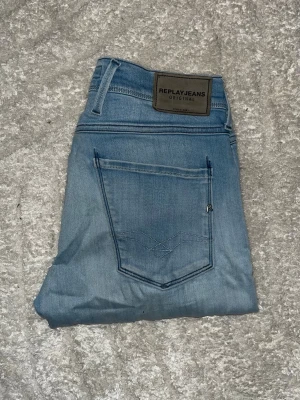 Replay Anbass jeans  - Ljusblåa Replay Anbass jeans. Obs jeansen har ett hål på ena knät. Midja 37cm, längd 106cm.  Om det inte finns en bild i annonsen där jag bär plagget på så kan jag ej ha det. För bättre inblick i passformen rekommenderar jag att googla på modellnamnet. För storleksguide kolla måtten noggrant då jeansen alltid kan vara uppsydda heller krympta och jag ej tar emot returer :) s6,5