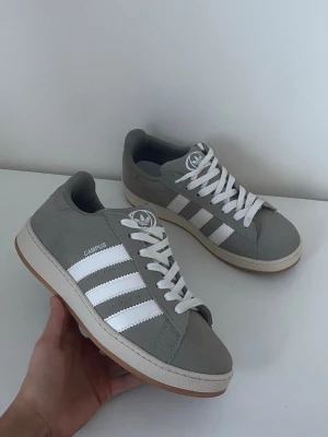 Adidas Campus sneakers – grå - Adidas Campus sneakers i grått med vita ränder.✔️ Klassisk modell som passar till allt ✔️ Sköna och tidlösa  Kan skickas snabbt. Skriv vid frågor eller fler bilder.