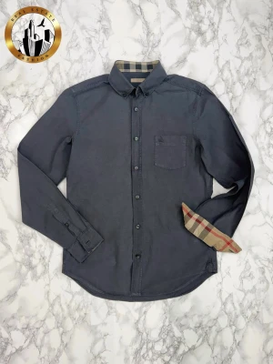 Burberry Skjorta S - Mörkgrå Burberry skjorta i storlek S i befintligt skick. Skjortan är självklart äkta. Är du osäker på äkthet hänvisar jag gärna till bra källor/guider. Tveka inte på att höra av dig för fler frågor eller vid minsta fundering! Skick: 7/10