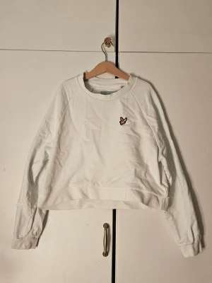 Vit sweatshirt från Lyle & Scott - Säljer en vit sweatshirt från Lyle & Scott. Tröjan har rund halsringning, långa ärmar och ribbade muddar. Perfekt för en clean och enkel stil. Materialet känns mjukt och skönt mot huden.