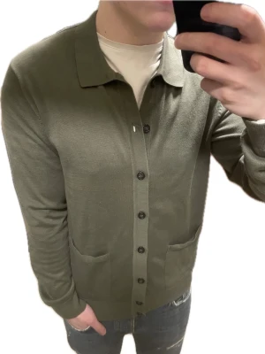 Grön stickad cardigan - Otroligt snygg grön stickad cardigan. Passar perfekt till kallare väder. Modellen är 180cm, 75kg. Priset kan såklart diskuteras!