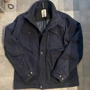 J.Lindberg fieldjacka - Säljer denna riktigt feta mörkblå J.Lindberg jacka, något tjockare så perfekt för kyligare dagar❄️ || Storlek: L || Skick; 7,5/10, Missfärgning (Bild 5) ,märks inte direkt under användning. || Pris: 1099 || Om du är osäker på storlek skickar jag mått!