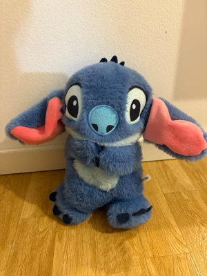 Ångest dämpande gosedjur - Stitch gosedjur med lugnande funktioner. Spelar stillsamma godnattmelodier, har en andningsfunktion som rör sig rytmiskt samt mjukt ljus. Kan användas för avslappning, insomning eller som trygghet vid stress/ångest. I gott skick.