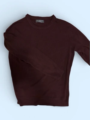 Vinröd stickad tröja  - Vinröd stickad tröja från Primark med rund halsringning och långa ärmar. Tröjan har en enkel och stilren design, perfekt för lager på lager och passar till det mesta. Tillverkad i mjukt material för skön känsla.