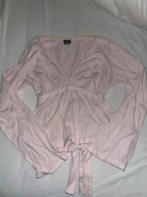 Ljusrosa tröja med en knut på baksidan! - En söt ljusrosa tröja från Gina med långa ärmar och knut bak. Storlek Xs