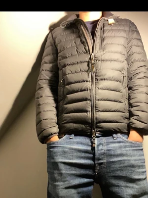 Svart pufferjacka från Parajumpers - Säljer en svart pufferjacka från Parajumpers med gul detalj vid kragen och patch på ärmen. Jackan har dragkedja framtill, två sidofickor med dragkedja och quiltad design. Perfekt för kalla vinterdagar och riktigt snygg till jeans.