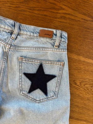 Subdued Ljusblå low waisted  jeans med stjärnor - Unika ljusblå jeans från subdued med raka ben och två stora mörkblå stjärnor på bakfickorna. .