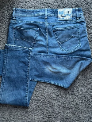 Jacob Cohën Second Premium Edition Jeans | J622 - Jacob Cohën - J622 COMF. Handgjorda i Italien. "Second Premium Edition" i snygg mellanblå tvätt & fantastiskt skick! 🧵 Modell: J622 (Modern Slim Fit) 📏 Storlek: W35 📐 Mått: A:42,5 B:76 C:102 cm 🧩 Material: Premium denim (Stretch) ✅ Skick: 9,5/10 (Som nya!) 💎 Detaljer: Silverknappar, broderat J & exklusiv mönstrad patch. 💰 Nypris: Ca 5500 kr🧍‍♂️ Ref: Passar ca 182-187 cm. Modellen är 189, men har dragit ner jeansen en del.Skriv för fler bilder! ‼️ Skickas direkt eller senast dagen efter betalning! ‼️ 