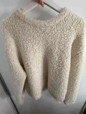 Krämvit fluffig stickad tröja Gina Tricot - Supermjuk och fluffig stickad tröja från Gina Tricot i krämvit färg. Tröjan har rund halsringning och en chunky struktur. Den värmer jättebra. 