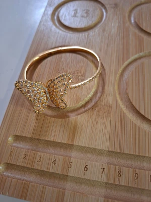 Guldarmband med fjäril och strass - Snyggt armband i guldfärg med en stor fjäril dekorerad med glittrande strass. Armbandet har en öppen design och fjärilen är detaljrik och gnistrar i ljuset. Perfekt accessoar för dig som gillar statement-smycken och vill sticka ut.