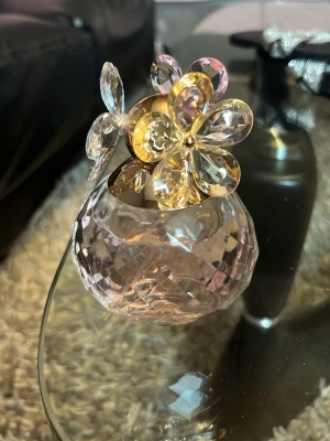Parfym flaska blommig doft  - Säljer en elegant parfymflaska från Marc Jacobs Daisy med en facetterad, ljusrosa glasflaska och ett guldigt lock dekorerat med stora, transparenta plastblommor. Perfekt som både doft och snygg inredningsdetalj.