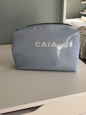 Ljusblå necessär från CAIA - Säljer en ljusblå necessär från CAIA men dragkedjan är sönder 