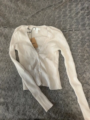 Beige ribbad kofta från H&M - Super fin kofta/topp från hm. Säljer då den inte kommer till användning, väldigt fint skick. Storlek xs