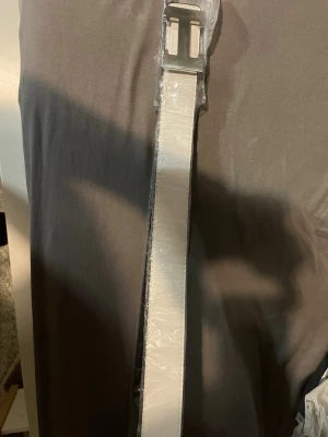 Vitt bälte med metallspänne - Snyggt vitt bälte med ett stilrent, fyrkantigt metallspänne. Bältet har en clean look och passar perfekt till jeans eller byxor där du vill ha en enkel men modern accessoar. Materialet känns slätt och bältet har raka kanter för en minimalistisk vibe.