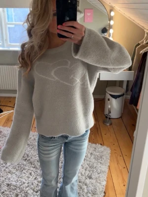 Grå stickad tröja! - Mjuk och fluffig grå stickad tröja med vitt hjärtmönster på bröstet. Jag säljer min Yamz tröja i storlek S! Den är i jättebra skick och säljer pga att jag inte får användning av den. Tröjan sticks inte alls utan är jätte len och skön att ha på sig. INTE MINA BILDER! Kontakta för egna bilder eller funderingar!💕