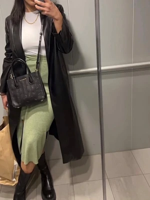 Grön ribbad midikjol med slits - Säljer en ljusgrön ribbad midikjol med slits framtill. Kjolen har en elastisk midja och är gjord i mjukt stickat material som sitter snyggt på kroppen. Perfekt att styla med boots eller sneakers för en cool look.