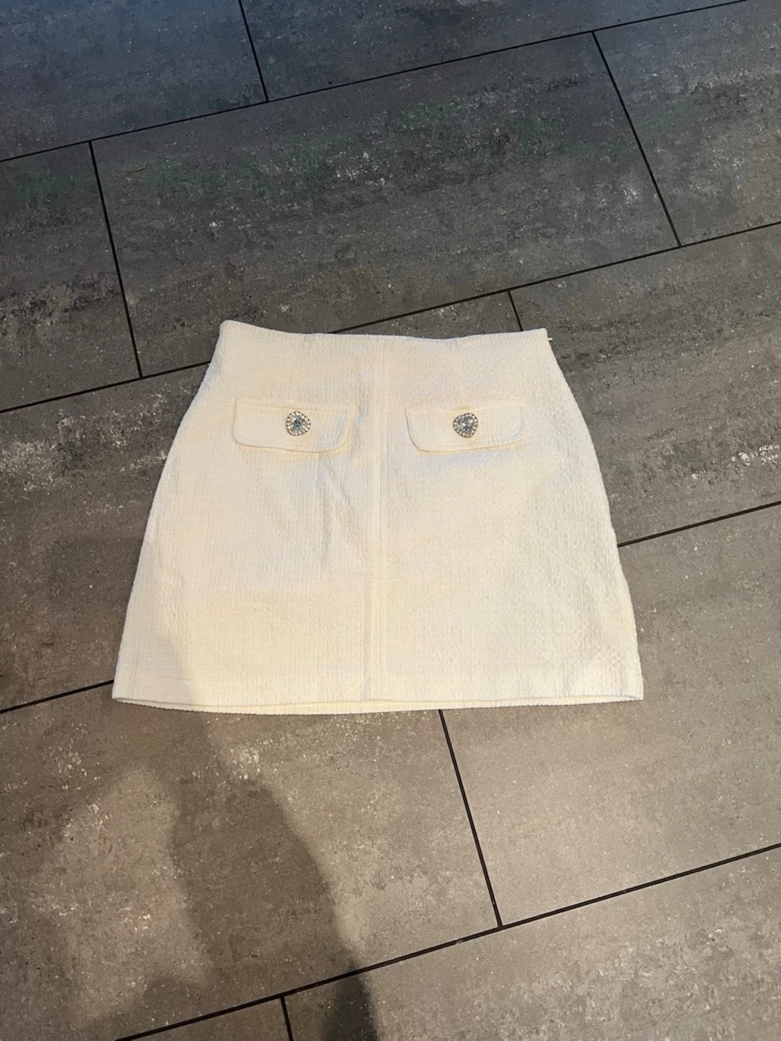 Vit kortkjol med fickdetaljer