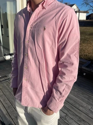 Ralph Lauren skjorta  - Säljer en klassisk rosa skjorta från Ralph lauren. Super skick, moddel är 186cm