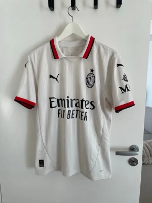 AC Milan vit  Puma - AC Milan, Tröjan har klubbmärke, Puma-logga och sponsorer tryckta på bröst och ärm. Tillverkad i lätt och ventilerande. Trycket på ryggen är personligt utvalt. 