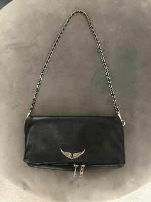Zadig & Voltaire väska - Säljer min svarta Zadig väska som fortfarande är i ett fint skick🖤Lite slitage på kedjan och dragkedjorna men inget som man lägger märke till (syns på bilderna). Kommer med både ett långt och ett kortare band, går även att ha som clutch. Köptes för 3600 kr har kvittot och original påsen till💗