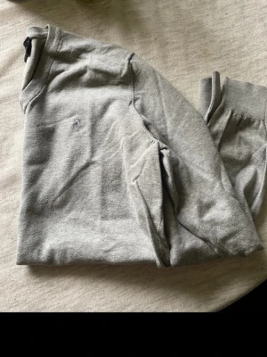 Grå sweatshirt från Peak Performance - Snygg grå sweatshirt från Peak Performance med diskret logga på bröstet. Tröjan har rund halsringning och ribbade muddar vid ärmslut och nederkant. Perfekt för en avslappnad och stilren look.