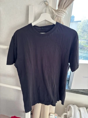 4 svarta Tshirts  - En klassisk svart t-shirt från Weekday med rund hals och korta ärmar. Tillverkad i mjuk bomull för en skön och avslappnad känsla. Perfekt att matcha med jeans eller shorts för en enkel och clean look.