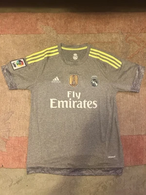 Real Madrid jersey - Säljer denna snygga och i princip helt nya real Madrid matchtröja från säsongen 2015/2016 med Gareth bale på ryggen, nummer 11. Riktigt snygg och även sällsynt tröja! Tröjan är i storlek M och har knappt använts. Pris kan diskuteras!! Tveka inte att skriva!!