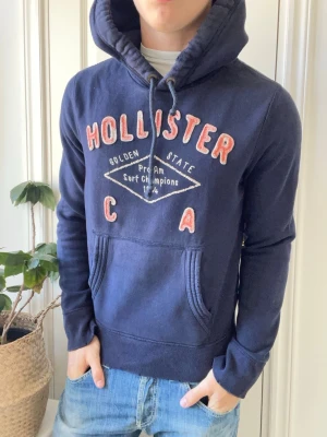 Hollister California hoodie  - Hollister California hoodie, Inga defekter! Modellen i bilderna är 180 cm 75 kg och bär Storlek S , Kom med frågor! 🌟 (Kan gå ned i pris vid köp av paket 😉) 