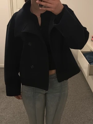 Marinblå populär kappa från ginatricot - Stilren marinblå kappa. Jackan är tillverkad i lite tunnare material som funkar till vår och hösten i Sverige! Enkel att matcha med olika outfits och en favorit hos mig, säljes då jag har en likadan i en annan färg. Storlek xs men skulle säga att den funkar som en S också!