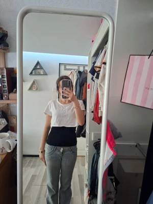 Vit croppad t-shirt med kort ärm - Säljer en fin vit croppad t-shirt med kort ärm och rund halsringning. Enkel och stilren design som passar perfekt till jeans eller kjol. T-shirten har en loose passform och är tillverkad i mjukt material. Obs säljer bara T-shirten inte linnet under men tycker det är väldigt fint att ha ett linne under. Står storlek XL men skulle typ helt ärligt säga att den känns som en storlek S. Använd ändast nån gång.