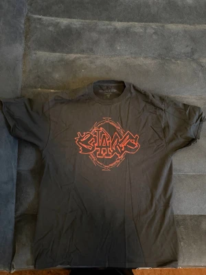 Bladee razorwire tee  - Säljer en svart bladee razorwire t-shirt med ett stort rött grafiskt tryck på bröstet och en liten draingang i nacken. Knappt använd. Klassisk passform och rund halsringning. 