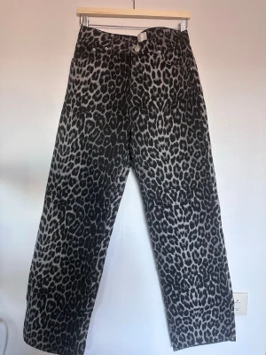 Leopardmönstrade jeans med raka ben - Säljer ett par coola jeans med svart och grått leopardmönster. Jeansen har raka ben och klassisk femficksdesign. Perfekt för dig som vill sticka ut och addera lite edge till din outfit. Materialet är denim och passformen är rak.