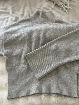 Grå stickad polo tröja - Säljer denna super mysiga stickade polo tröjan från gina tricot. jättebra skick utom att det finns ett litet hål i vänstra ärmen, men inget märkvärdigt alls! ❣️🥹