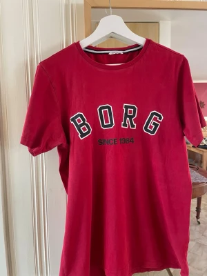 Röd Björn Borg t-shirt herr - Snygg röd t-shirt från Björn Borg med trycket 'BORG SINCE 1984' på bröstet. Klassisk rund halsringning och korta ärmar. Perfekt för en avslappnad och sportig stil. Stl S / M fashionformen #vinted #vintedsverige #märkeskläder #brandclothes #designer #menswear #herrkläder #original #äkta #secondhand #preloved #hållbartmode #streetwear #fashionformen #outfitformen #klädertillsalu #säljes #fynd #braSkick #snabbaffä
