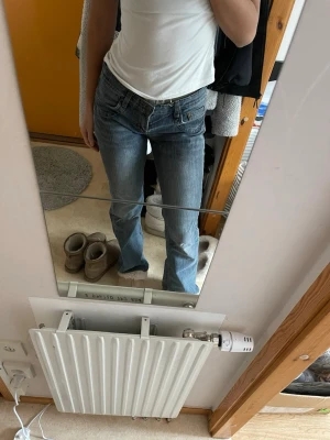 Blå bootcut jeans med låg midja - Säljer ett par blå bootcut jeans med låg midja. Detta är min mammas gamla jeans ifrån Thailand tror jag så ingen aning vart de kommer ifrån 🔥innerbens längd ca 85cm🫶🏼