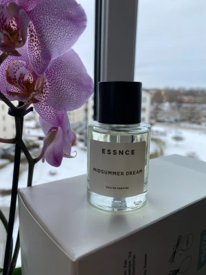 ESSNCE Midsummer Dream parfym - Fräsch parfym från ESSNCE med namnet Midsummer Dream. Flaskan är cylindrisk i genomskinligt glas med svart rund kork och enkel vit etikett. Modern och stilren design som passar perfekt på parfymhyllan. Helt ny, max 10 sprut tagna. Alt byte mot samma mängd Tarte au Citron 