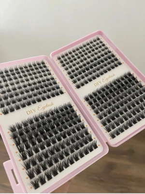 DIY fransar i mixad längd - Säljer ett kit med svarta individuella lösögonfransar från DIY Eyelash. Fransarna kommer i en rosa ask och finns i olika längder och tjocklekar för att skapa en personlig look. Perfekt för dig som vill bygga egna fransar hemma. Materialet är syntetiskt.