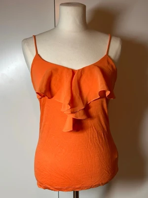 Orange topp med volanger  - Orange topp med volanger. Storlek s från h&m.  Köp sker via köp nu, jag postar inom 24h. Kvar tills markerad såld