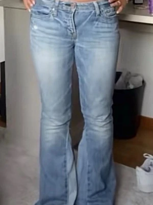 Ljusblå bootcut jeans Gap 1969 - Säljer ett par ljusblå bootcut jeans från Gap 1969 med klassisk femficksmodell och slitna detaljer. Jeansen har mellan låg midja och utsvängda ben,. Tillverkade i mjuk denim med snygg tvätt. Passar mig perfekt i längden som är 154cm. Midjemåttet är 38cm och innerbenslängden 71cm