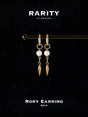 Rory Earring guldörhängen - Snygga örhängen från Rarity of Sweden i guld med vita pärlor och droppformade hängen. Kombinerar klassisk pärldesign med moderna detaljer i guldfärgat metall. Perfekta för dig som vill ha något unikt och trendigt.