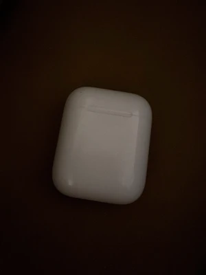 Apple AirPods med laddningsetui - Säljer ett par vita Apple AirPods med tillhörande laddningsetui. Trådlösa hörlurar i stilren och kompakt design, perfekt för musik, samtal och poddar. Etuiet är i hårdplast och har en LED-indikator på insidan. Smidig att ta med överallt. Boxen finns. 