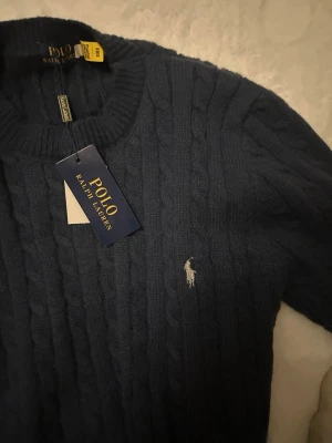 Mörkblå kabelstickad tröja Polo Ralph Lauren - Säljer en skit fet raffe tröja som aldrig använts, köpte den på nätet men den var tyvär för liten.