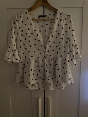 Prickig blus/topp - Säljer denna superfina prickiga blus topp som köptes på plock för ett år sedan men endast testad, säljer då den ej kommer till användning. Tröjan saknar en knapp i mitten som syns på bilden men inget som direkt syns på och är ett jätte enkelt fix!💗 skulle säga att den passar mer S/XS men tror det står M på lappen.