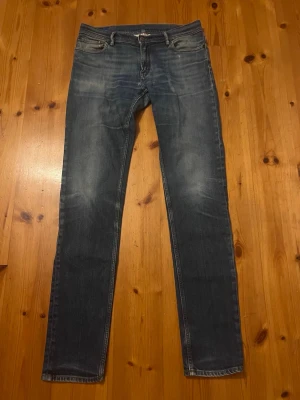 Acne Jeans - Säljer ett par klassiska blå jeans från Acne Studios Blå Konst. De har en smal passform, fem fickor och snygga slitningar på låren. Tillverkade i Italien och gjorda av denim med en autentisk tvättad look. Inga defekter