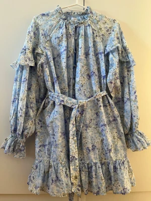 Klänning - Blommig klänning från Other stories. Volang i krage, ärmslut och längst ned. 